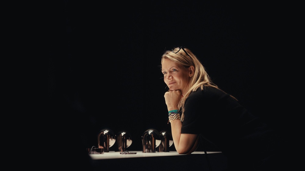 Woman with blonde hair in the Occhio showroom in Munich, Luna Pura lamps behind her