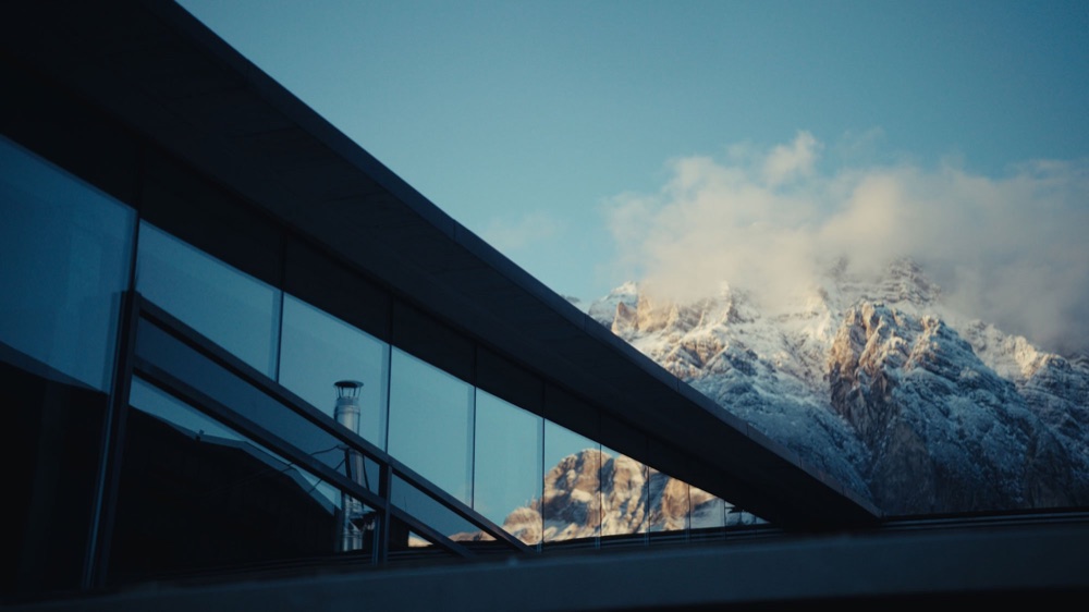 Glass façade of the Krallerhof with mountains behind