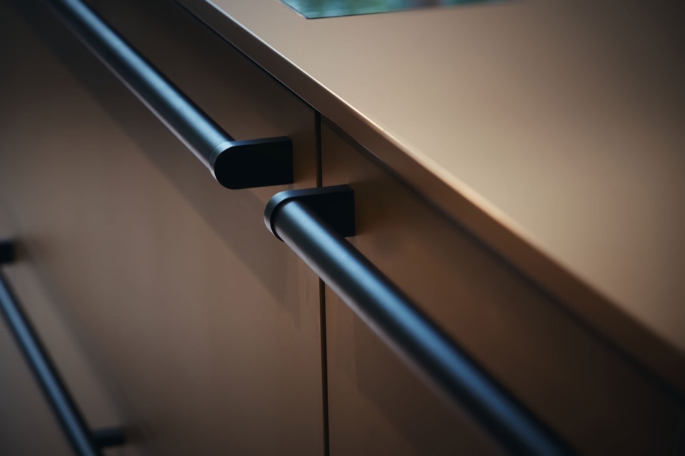 Close-up of drawer handles on a beige next125 kitchen