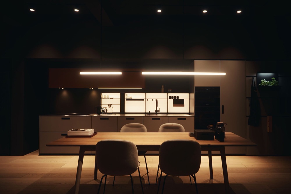 Beige next125 kitchen with a wooden dining table, four armchairs and two light bars above